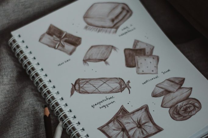 Dibujo de almohadas y mantas en un cuaderno, con detalles de diseño y texturas.